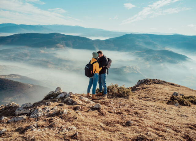 happy,couple,man,and,woman,tourist,at,top,of,mountain
